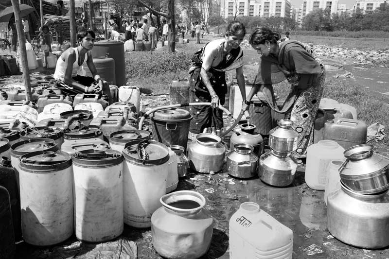 Struggling to fill long queues of containers with little water at low pressure at a group connection in Mumbai, Maharashtra